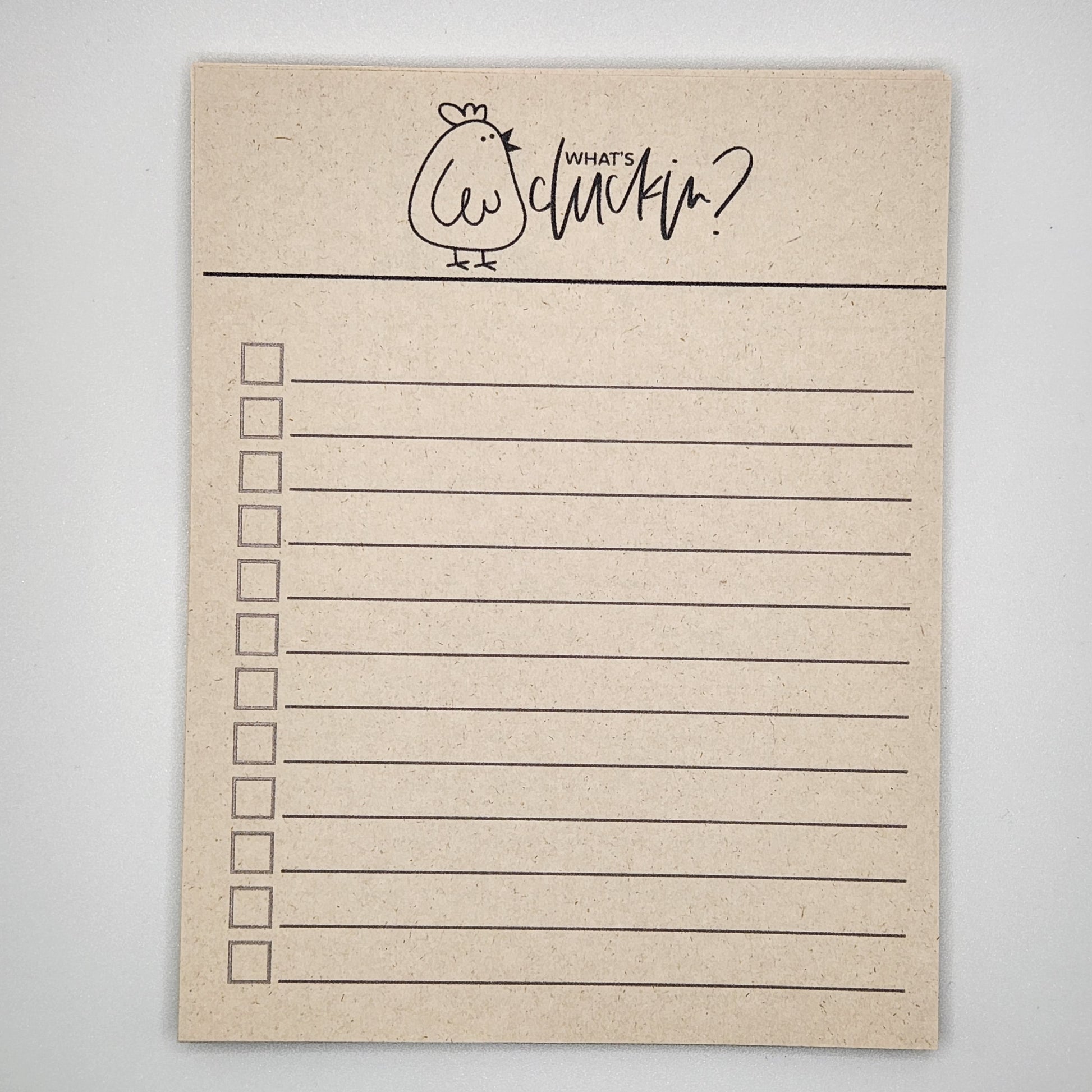 Natural sugarcane notepad on white background. Cartoon chicken at the top is very plump and the words What's cluckin? are to the right of the chick.  Check boxes with lines fill the remainder of the page.