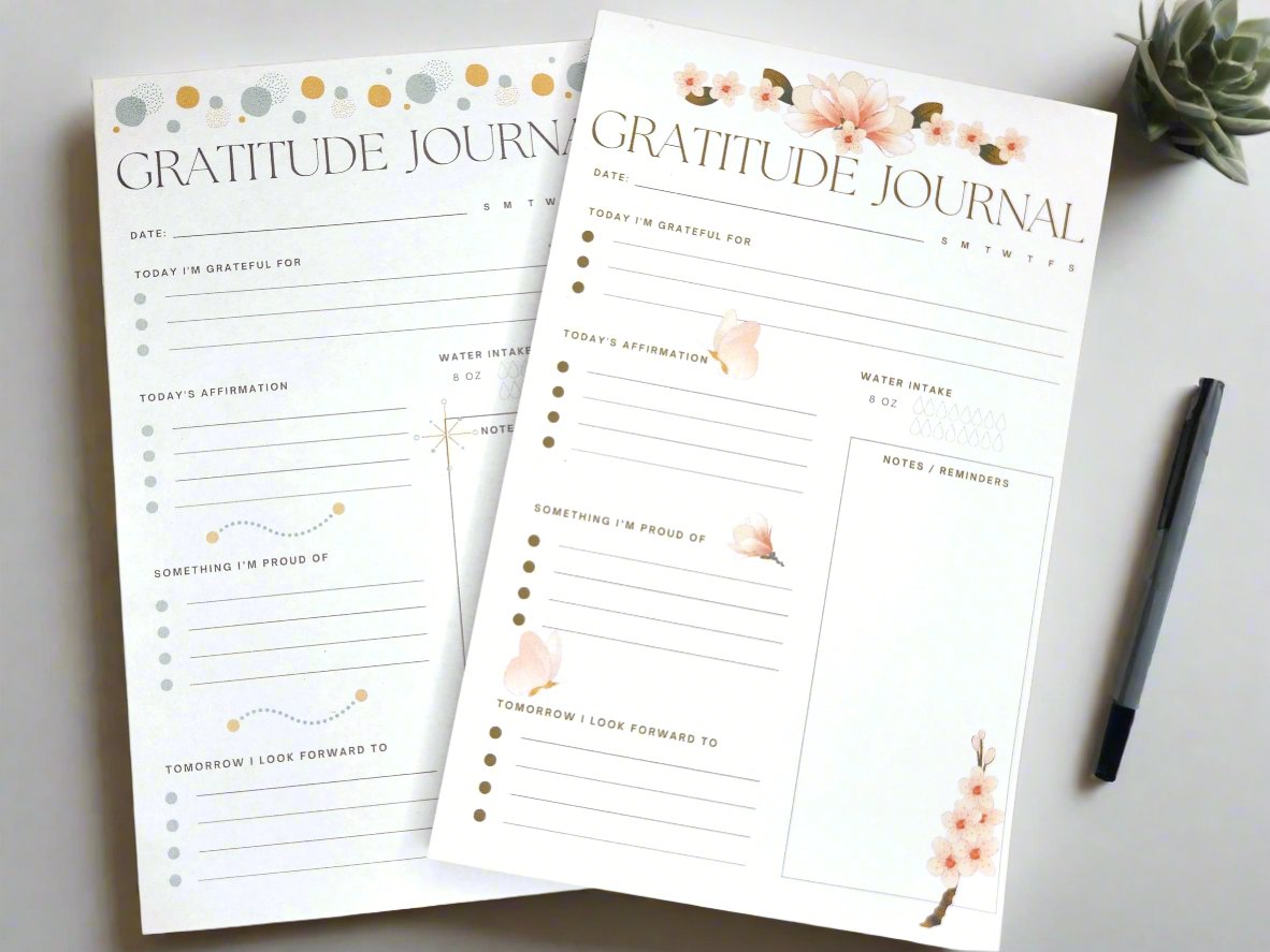 Two gratitude padded journals sitting on a wooden desk.