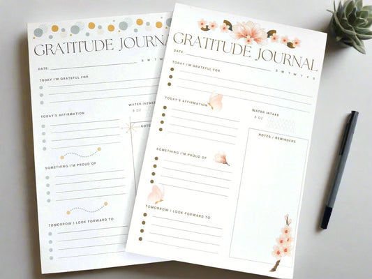 Two gratitude padded journals sitting on a wooden desk.