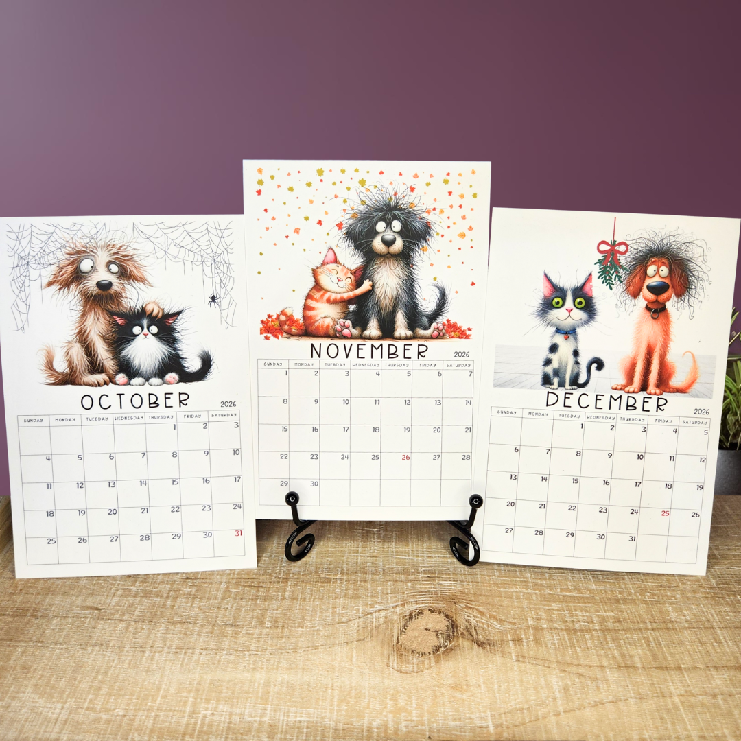 Calendar with illustrations of dogs and cats for October, November, and December on a wooden surface.