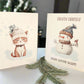 Two Christmas cards featuring a cat and a snowman with text 'Frosty Friends make winter warm' on a white surface.