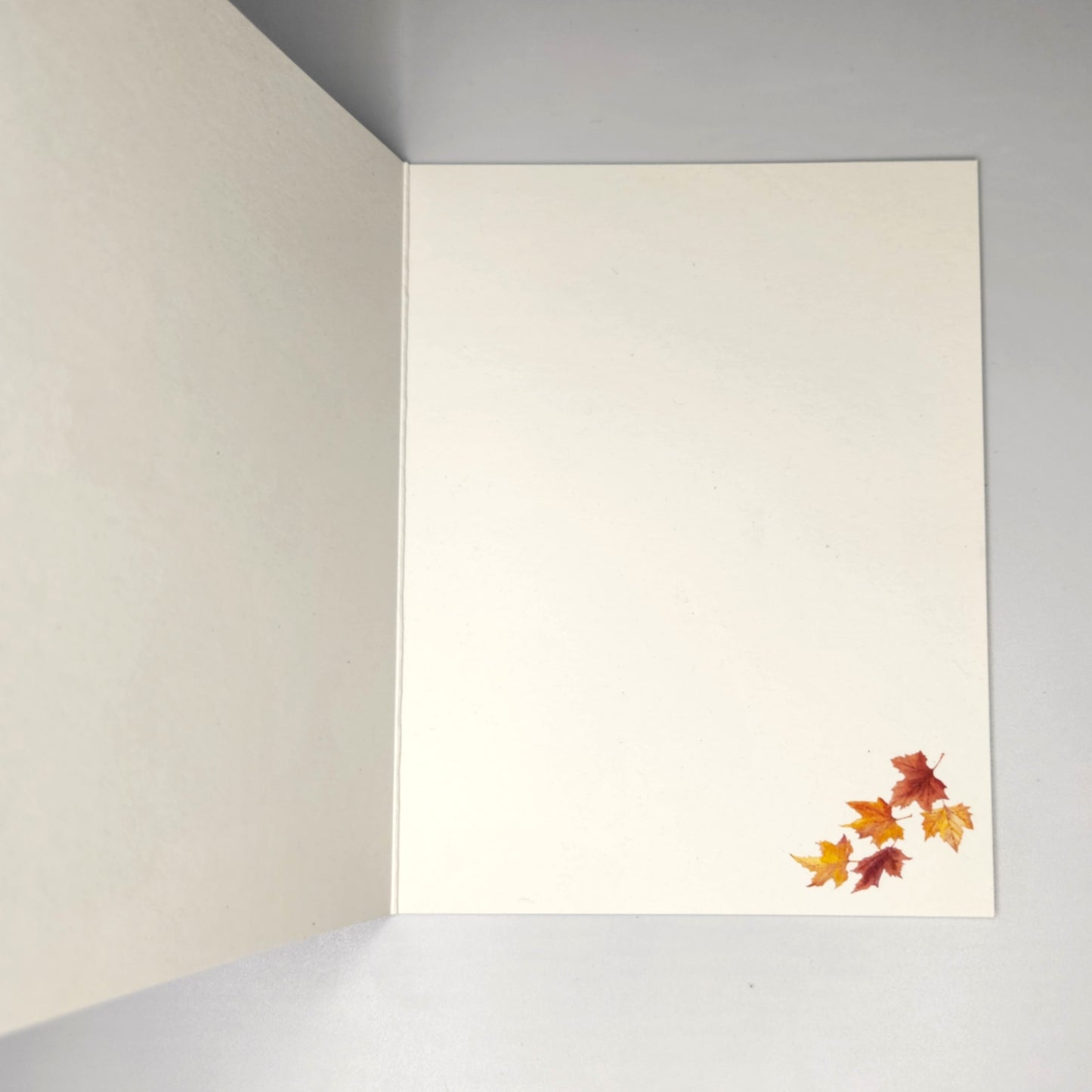 inside of the card showing blank with leaves in the lower right corner