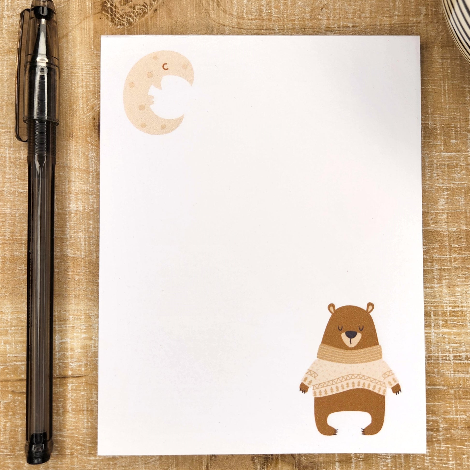 notepad with sleepy bear in bottom right corner and moon in the upper left corner. 