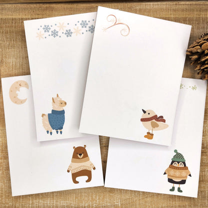 four scandi inspired notepads featuring each animal in a sweater or scarf.  bear, llama, bird and duck.