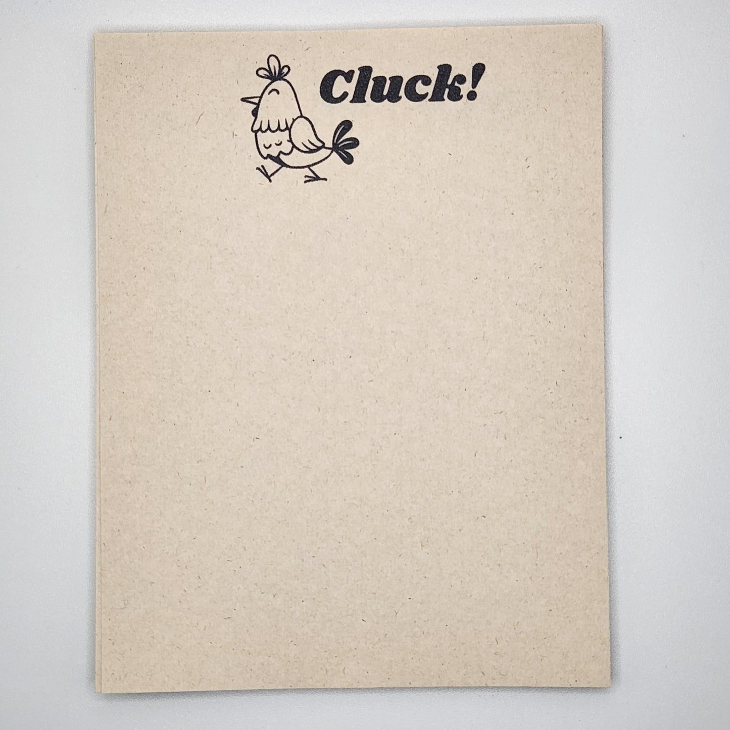 Natural sugarcane notepad on white background.  Chicken at the top is walking tot the left and the single word Click! is to the right of the chick.  Remainder of notepad is blank. 