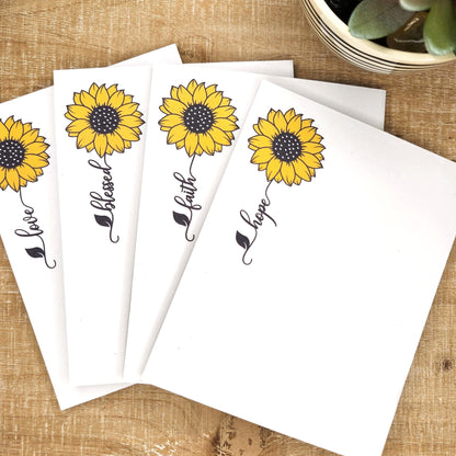 Four sunflowers each with a word trailing down from the flower.  love, blessed, faith, and hope