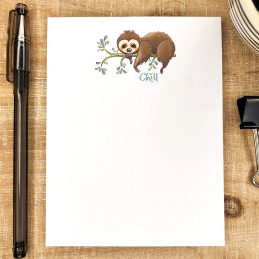 notepad with cute sloth hanging on a branch and the word 'chill' under the sloth.