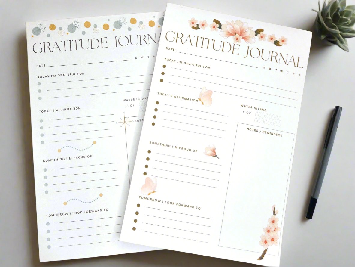 Two gratitude padded journals sitting on a wooden desk.  