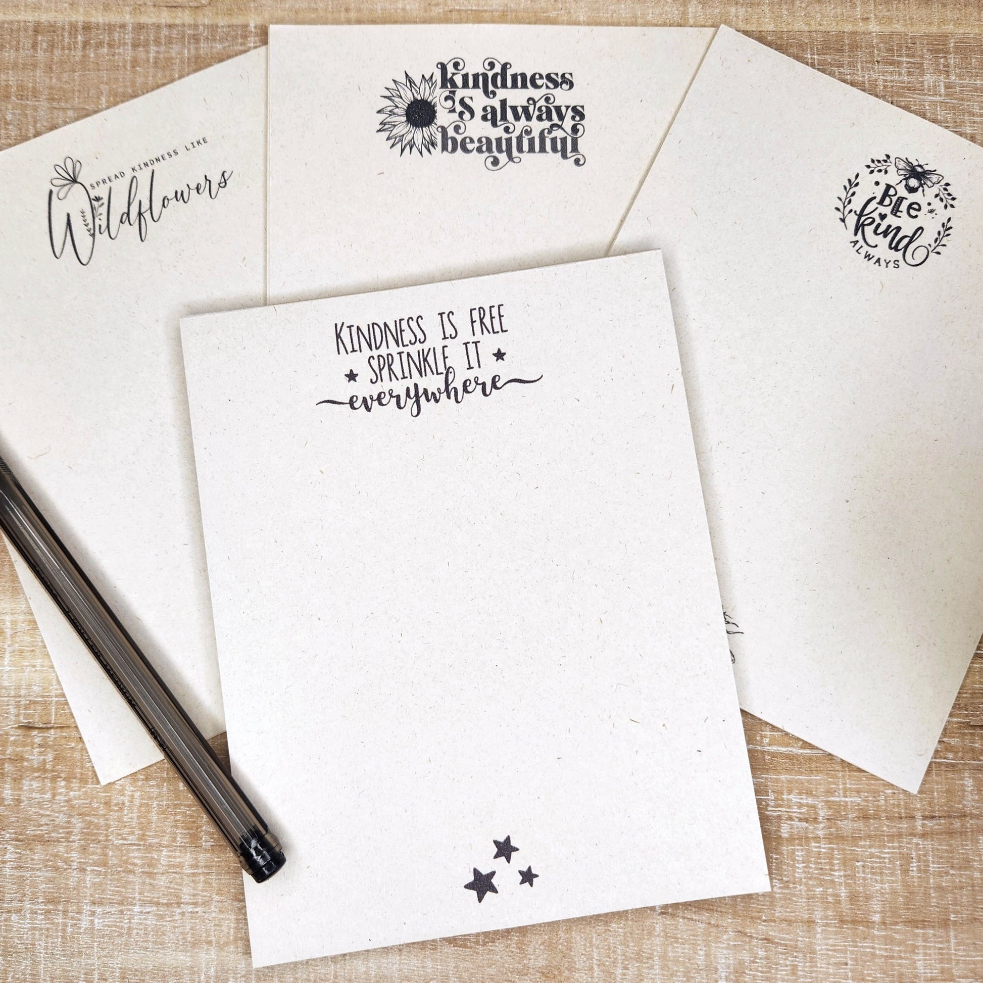 set of 4 notepads on a tan background. Each notepad has a saying about kindness. Please check each individual picture for specific wording. Printed on sugarcane paper.