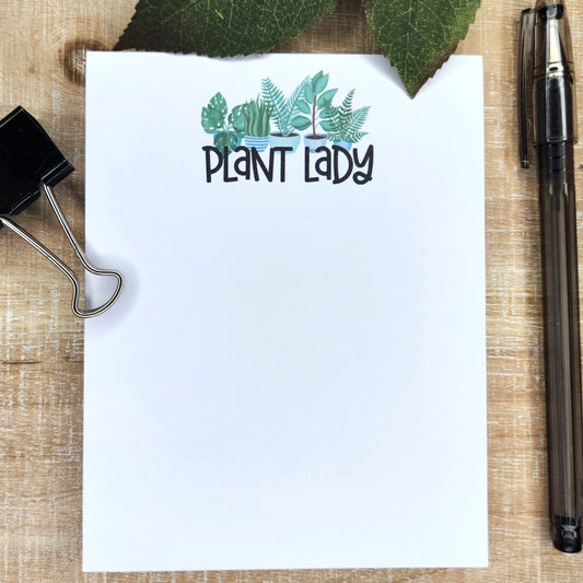 white notepad with the words 'plant lady' under potted green leaf plants.