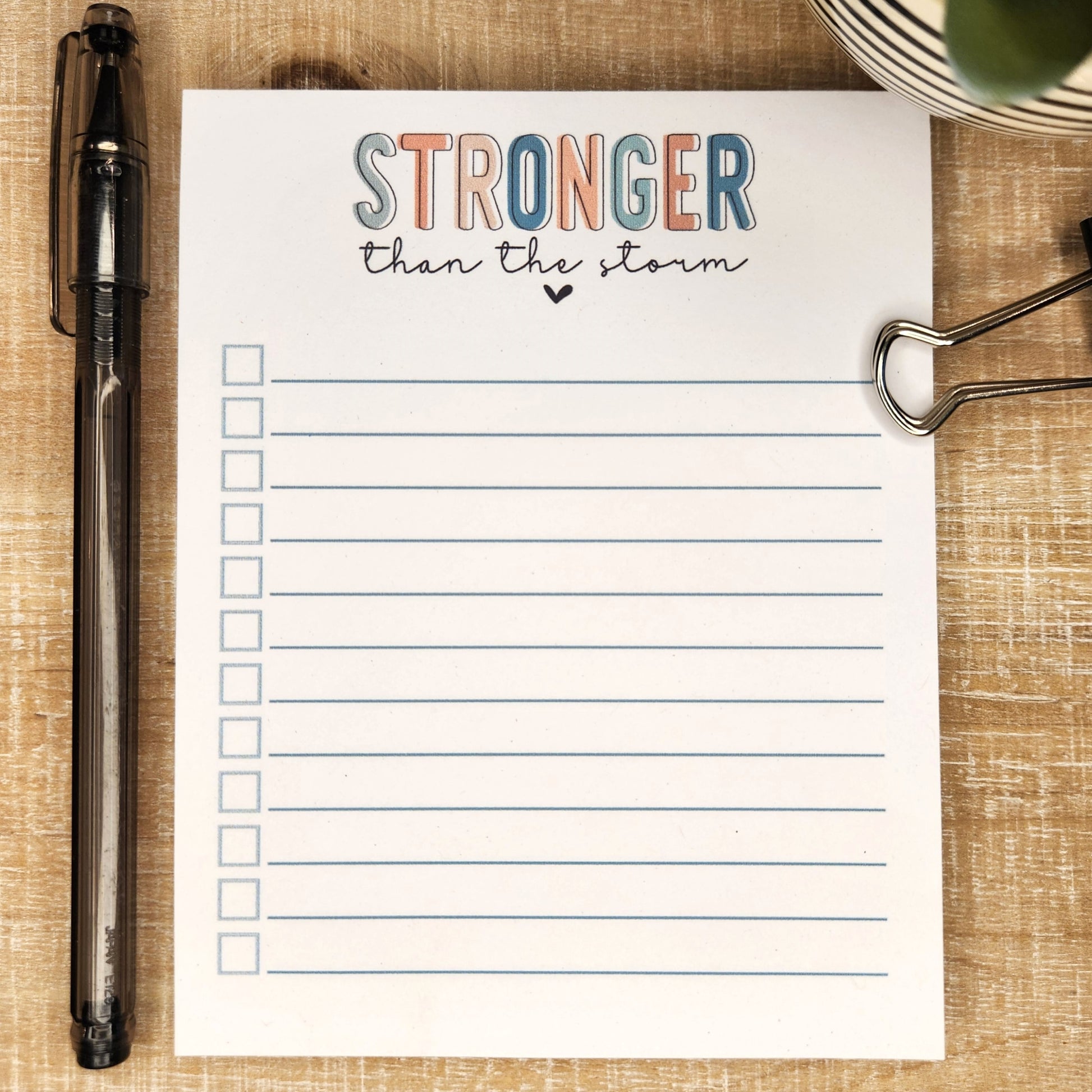 Stronger than the storm is written in block letters in various colors. Remainder of the notepad has lines and check boxes.