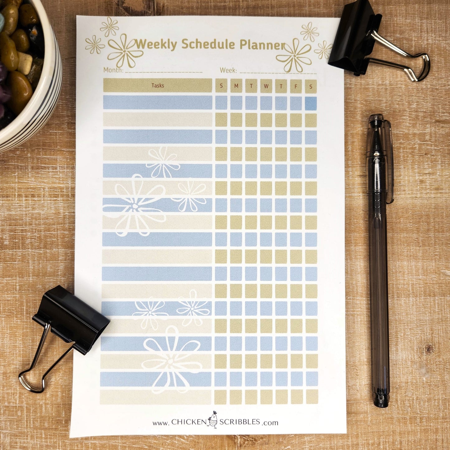 White notepad on wooden background. Notepad is a weekly schedule planner with days of the week and several lines to fill in the tasks. you can choose either tan and blue or pink and blush as the document colors.